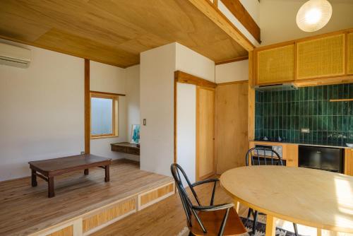 a room with a table and chairs and a kitchen at Yanagawa Guest House Horiwari in Yanagawa