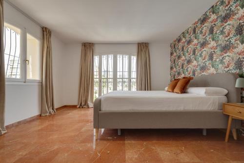 a bedroom with a bed and a large window at Villa Julieta y Romeo by Bookirentals in Benidorm