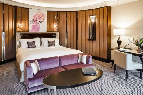 a hotel room with a bed and a couch at Sofitel Frankfurt Opera in Frankfurt/Main