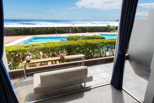 a room with a view of a pool and a couch at Kamogawa Grand Hotel in Kamogawa
