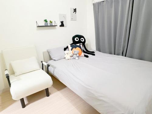 um quarto com uma cama com um pinguim empalhado e uma cadeira em 高田馬場7人可 02 em Tóquio