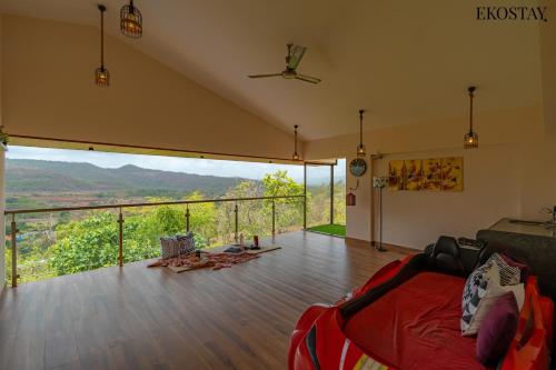 a room with a bed and a balcony with a view at EKOSTAY - Amani Villa in Khopoli