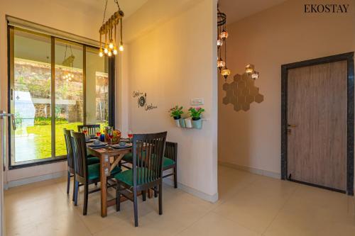 a dining room with a wooden table and chairs at EKOSTAY - Amani Villa in Khopoli