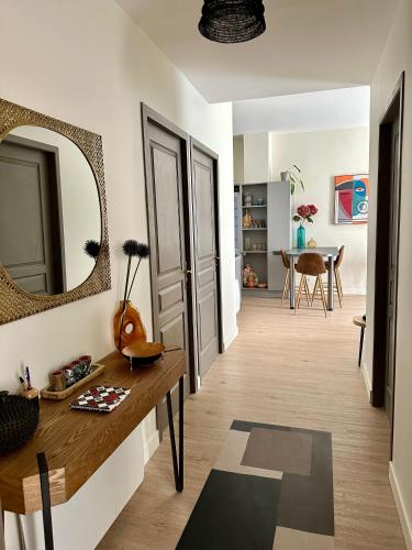 - un salon avec une table et un miroir dans l'établissement Coural’ Home, à Narbonne