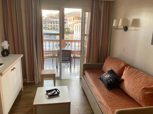 d'un salon avec un canapé et une vue sur un balcon. dans l'établissement CAP ESTEREL AGAY SAINT RAPHAEL VUE COEUR DU SITE PISCINE GOLF MER Studio 4 personnes chez Magali, à Agay