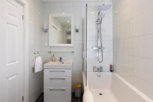 een witte badkamer met een douche en een wastafel bij Stag Lodge at Sherwood in Edwinstowe