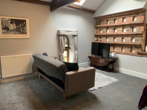 a living room with a couch and a mirror at Studio 3B The Carriage House York 6m Village Location in York