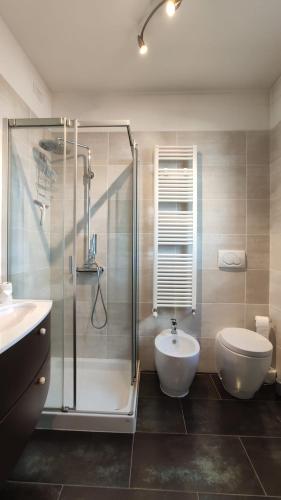 a bathroom with a shower and a toilet and a sink at Sui Generis penthouse with terraces in Milan