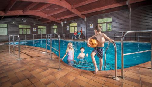 un bambino e due bambini che giocano in piscina di Tolroy Manor Holiday Park a Hayle
