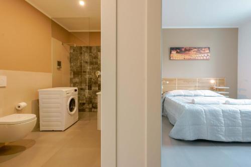 a bedroom with a bed and a bathroom with a washing machine at West Side Bologna Apartment in Bologna