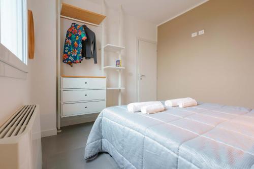 a white bedroom with a bed and a dresser at West Side Bologna Apartment in Bologna