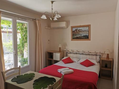 une chambre avec un lit, une table et une fenêtre dans l'établissement Résidence des Abeilles, à Avignon