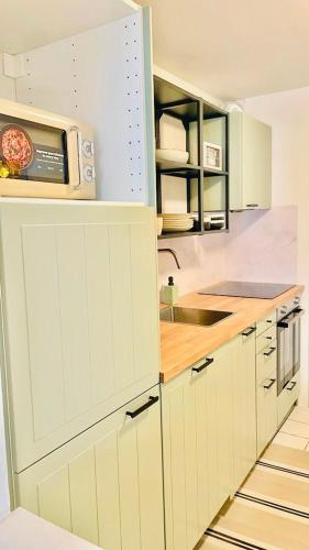 a kitchen with a microwave on top of a counter at Appart Brussels EXPO & ATOMIUM in Grimbergen
