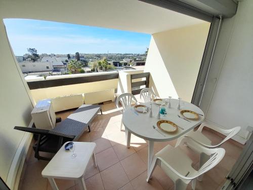 un balcon avec une table et des chaises et une vue dans l'établissement Appartement Village Naturiste Lagon, au Cap d'Agde