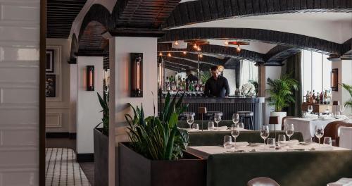 a restaurant with tables and a man standing behind the bar at Jumeirah Beach Hotel Dubai in Dubai