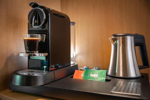 a coffee maker sitting on a table with a drink at ibis Styles Evry Courcouronnes Hotel and Events in Evry-Courcouronnes