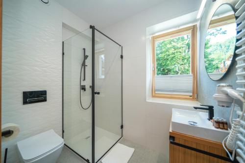 ein Bad mit einer Dusche, einem WC und einem Waschbecken in der Unterkunft Willa Pod Kolejką in Szczawnica