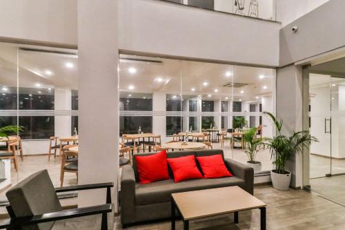 - un salon avec un canapé et des tables avec des oreillers rouges dans l'établissement Townhouse Reva College University, à Yelahanka
