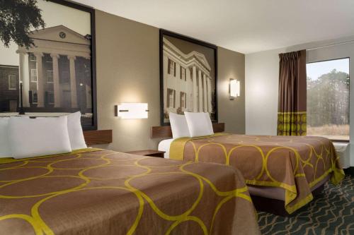 a hotel room with two beds and a window at Super 8 by Wyndham Pearl/Jackson/East in Pearl