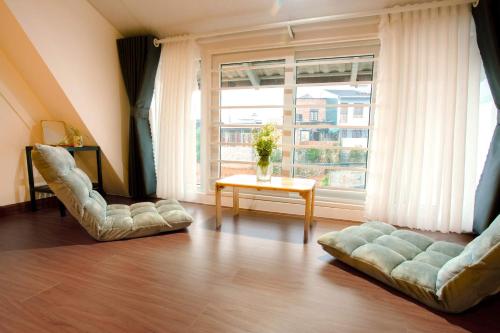a living room with two couches and a large window at Kimi Uchi Home in Da Lat