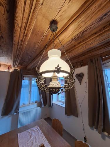 un lustre dans une pièce avec une table et des fenêtres dans l'établissement Gite premium, au Cœur de l'Ours, à Dambach-la-Ville