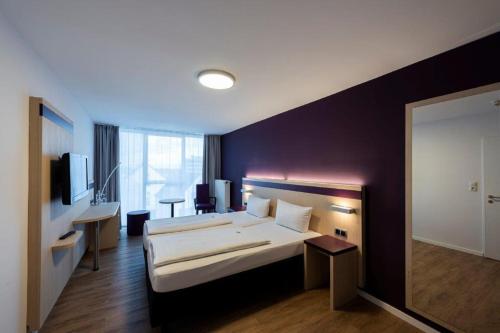 a hotel room with a bed and a desk at PANORAMA HOTEL in Neustadt an der Weinstraße in Neustadt an der Weinstraße