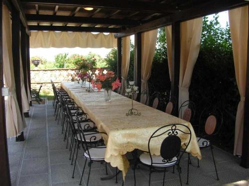 een lange tafel met stoelen en een lange tafel met bloemen bij Villa Bottaio in Foiano della Chiana