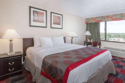 a hotel room with a large bed and a window at Ramada Plaza by Wyndham Albany in Albany