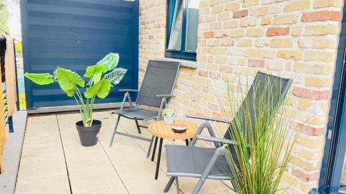 two chairs and a table on a patio with plants at Appart Brussels EXPO & ATOMIUM in Grimbergen