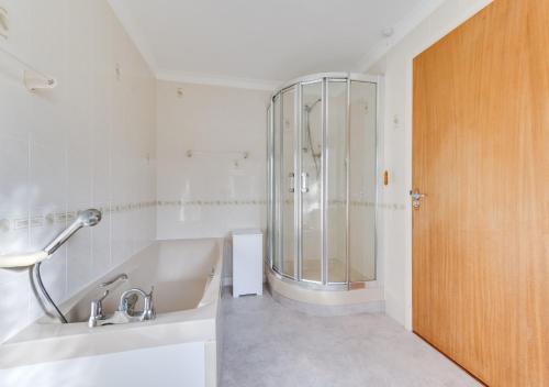 uma casa de banho com um chuveiro, um lavatório e uma banheira em Willow House em Halesworth
