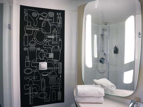 een badkamer met een zwart-witte muur en een spiegel bij ibis Caen Porte De Bretagne in Bretteville-sur-Odon