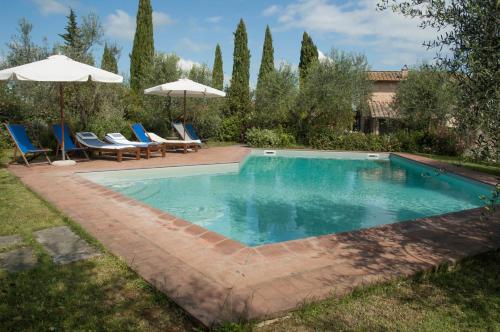 uma piscina com cadeiras e guarda-sóis num quintal em Lungagnana Apartment Cielo em Nebbiano