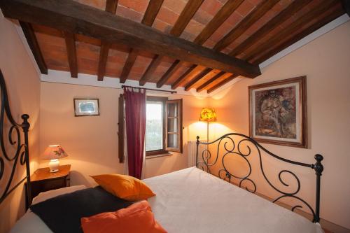 um quarto com uma cama com lençóis brancos e almofadas laranja em Lungagnana Apartment Cielo em Nebbiano