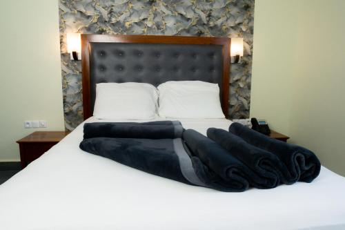 a bed with a black and white blanket on it at CINCINNATI HOTEL YAOUNDE in Yaoundé