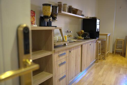 a kitchen with a counter with wooden cabinets and a microwave at Boutique Hostel Livia in Metković