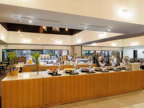 a restaurant with a counter with dishes on it at Mercure Kakadu Crocodile in Jabiru