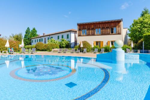 una grande piscina con un edificio sullo sfondo di Active Hotel Paradiso & Golf a Peschiera del Garda