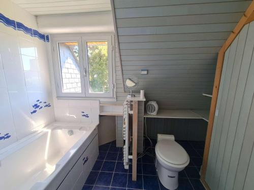 uma casa de banho com um WC, uma banheira e um lavatório. em Ref 067 Maison proche golfe du Morbihan pour six à huit personnes à louer pour les vacances em Arzon