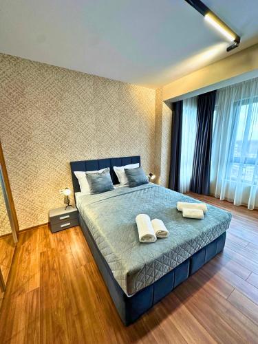 a bedroom with a bed with two towels on it at WEST POINT DELUXE APARTMENT in Plovdiv