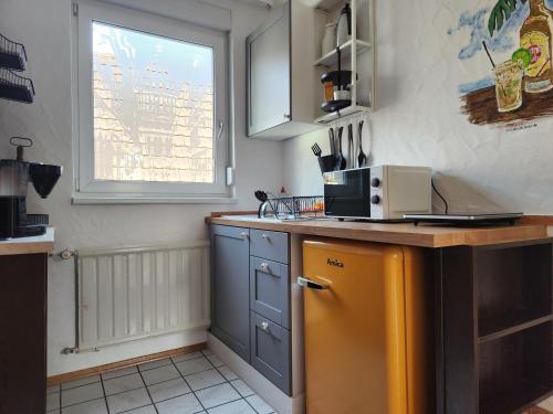 a kitchen with a yellow refrigerator and a window at Gästehaus Parkblick in Rust