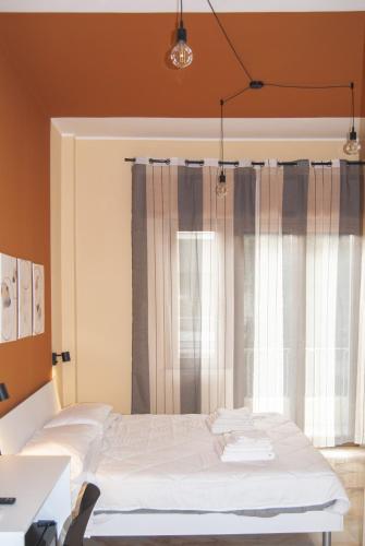 a bedroom with a white bed and a window at Le Sere in Reggio Calabria