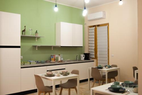 una cocina con 2 mesas y sillas y una barra en Le Sere, en Reggio Calabria