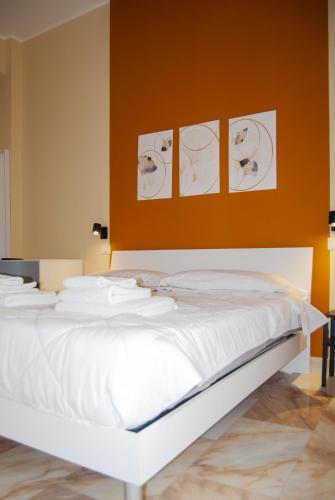 a bedroom with a white bed with drawings on the wall at Le Sere in Reggio Calabria
