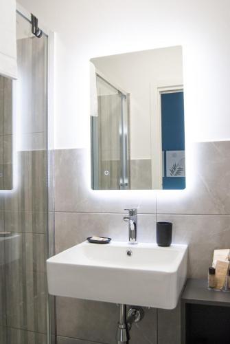 a bathroom with a white sink and a mirror at Le Sere in Reggio Calabria