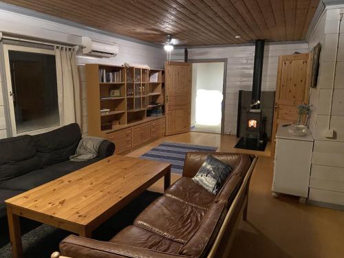 ein Wohnzimmer mit einem Sofa und einem Holztisch in der Unterkunft Cozy cottage on a large natural plot in lovely Harjedalen in Vemdalen