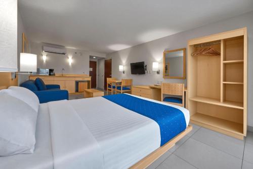 a bedroom with a large bed and a living room at City Express by Marriott Xalapa in Xalapa