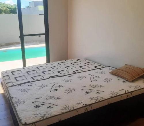 a bed in a room with a view of a pool at Recanto Shalom in São Carlos