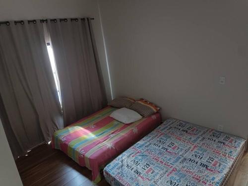 a small bedroom with a bed and azeb at Recanto Shalom 3 dormitórios in São Carlos