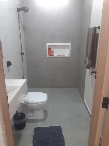 a white bathroom with a toilet and a sink at Recanto Shalom 3 dormitórios in São Carlos