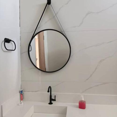 a bathroom sink with a mirror on the wall at Recanto Shalom 3 dormitórios in São Carlos